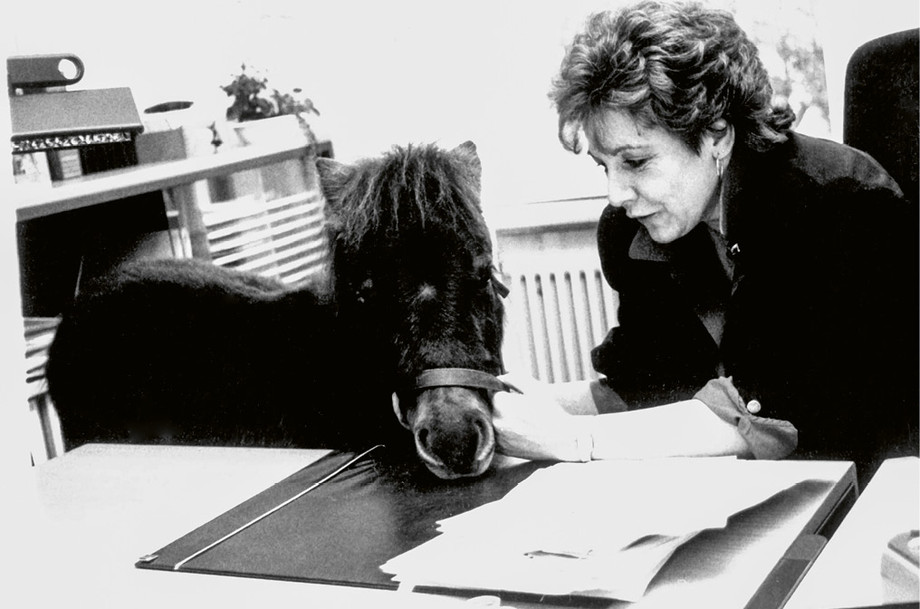 Arlette Blanche à son bureau au secrétariat en 1991. Le poney passait au secrétariat en raison de la fête des 25 ans de service du secrétaire général René Pezold. ©Roland von Siebenthal