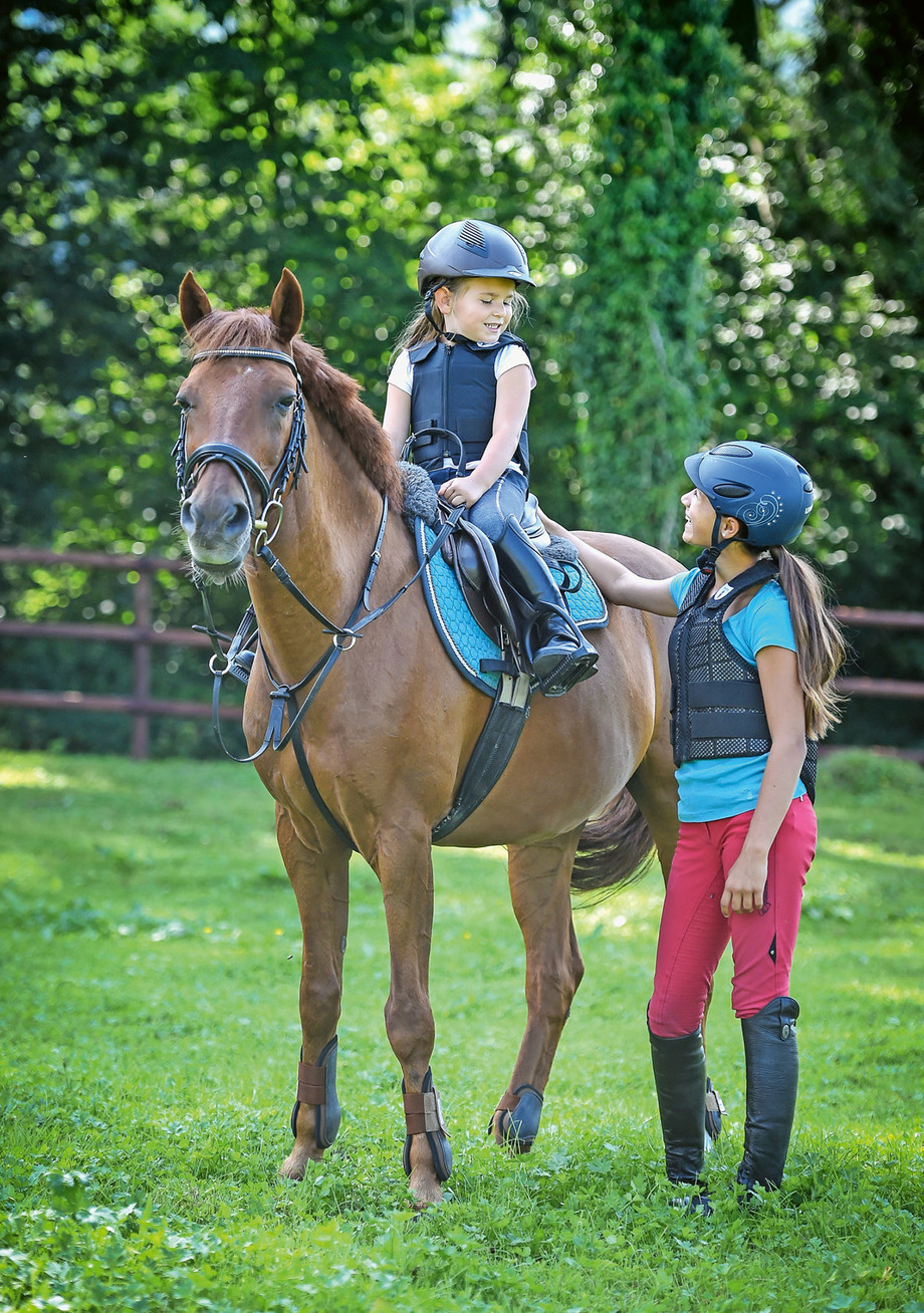 Schutzausrüstung wie Helm und Rückenprotektor mindern das Verletzungsrisiko bei Unfällen im Pferdesport. | © Katja Stuppia