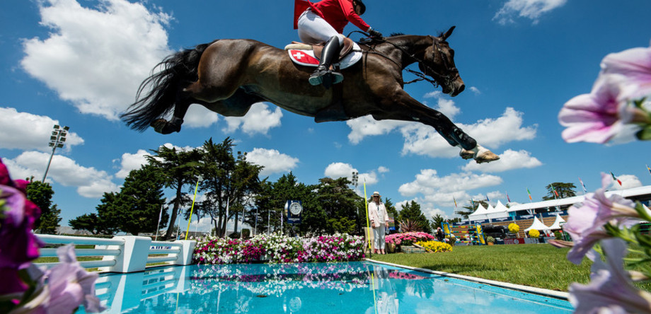 Martin Fuchs of Switzerland on Conner 70 tackles a water jump in the FEI Jumping Nations Cup of France at La Baule, France, June 11, 2021.